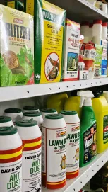 A Shelf Displaying Various Insecticides And Pest Control Products In Organized Rows